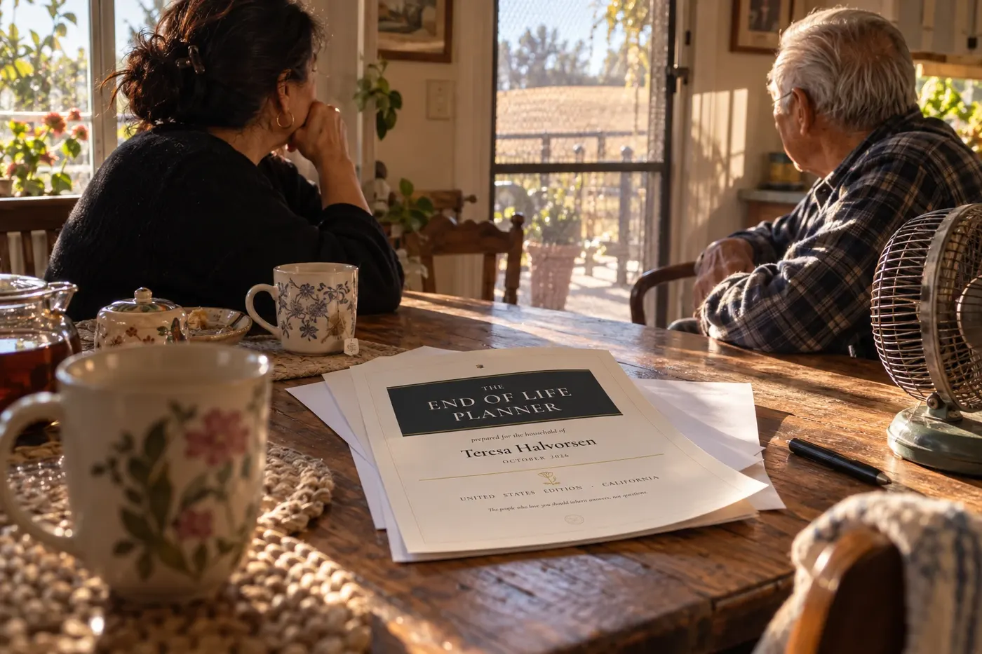 Two people at a farmhouse table with the printed planner and a pot of tea